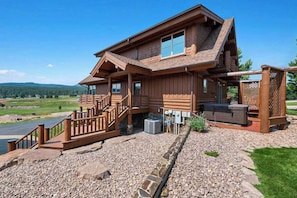 A log cabin with a porch, a staircase, and a view of the surrounding landscape. - Reunion Lodge - Hot Tub, Game Room & Views (Sturgis)