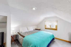 A bedroom with a bed, a nightstand, a lamp, and a window. - Friends & Family Base Camp - Dog-Friendly 3-Story Group Getaway (Woodland Park)