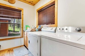 A laundry room with a washing machine, dryer, and a window with blinds. - Boulder Ridge Lodge - Hot Tub Log Cabin Near Golf Course (Lead)