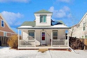 Ein zweistöckiges Haus mit einer Veranda, einem Briefkasten und der Hausnummer 750 an der Tür.
