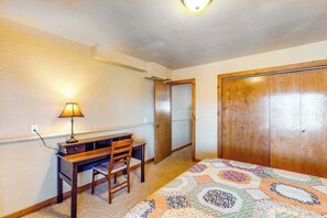 Ein Schlafzimmer mit einem Bett, einem Schreibtisch, einem Stuhl, einer Lampe und einem Kleiderschrank.