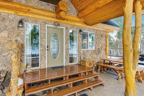 A stone building with a wooden porch, wooden benches, and a stone wall. - Tetro Rock Retreat - Game Room & Forest Views (Deadwood)