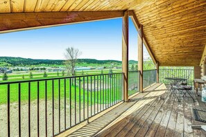 A wooden deck with a view of a green landscape and a clear sky. - Waterwheel Retreat - Classic Home • Hot Tub & Cozy Loft (Sturgis)