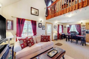 Ein Wohnzimmer mit einer Couch, einem Couchtisch und einem Essbereich mit Tisch und Stühlen.