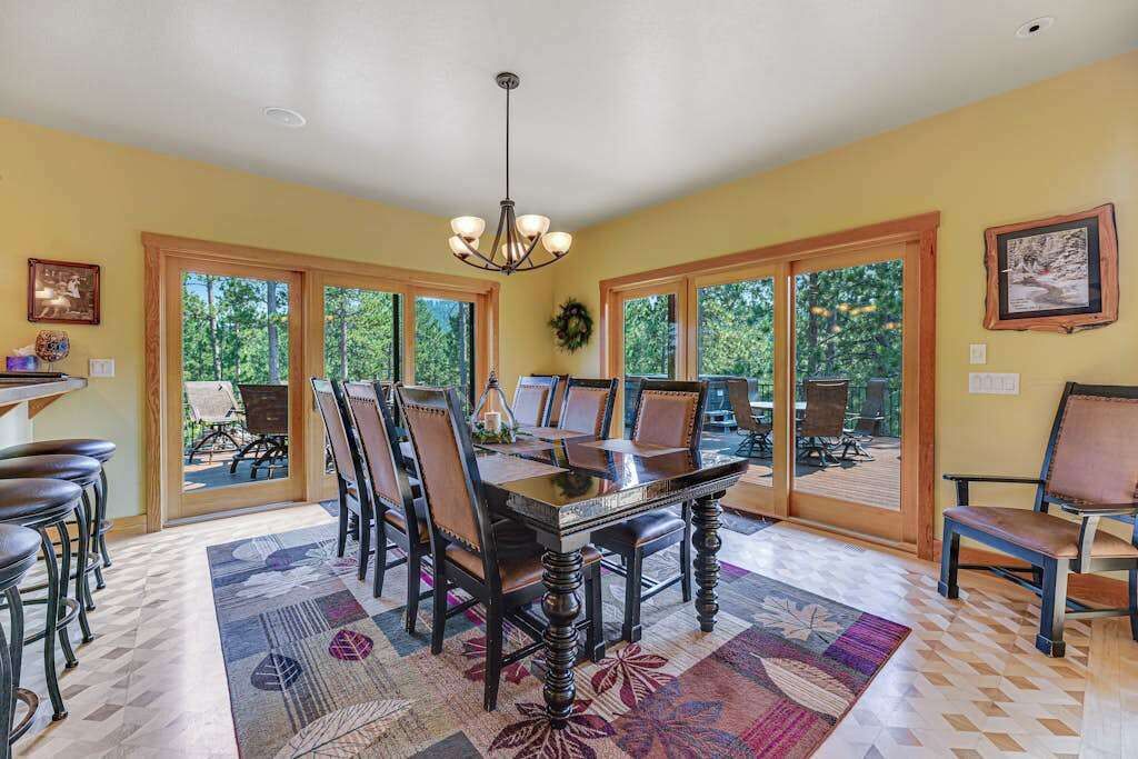 A dining area with a large table, chairs, and a chandelier.