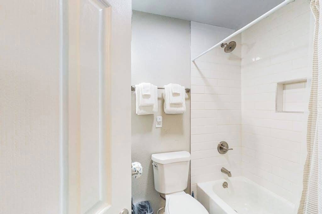 A bathroom with a toilet, a shower, and a bathtub.