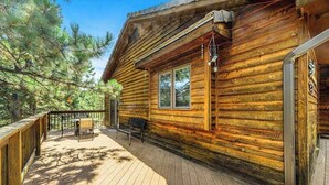 A wooden cabin with a deck, a table, and chairs. - Crooked Canyon Lodge - Secluded Lodge • Sauna & Hot Tub (Rapid City)