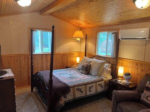 A cozy bedroom with a four-poster bed, two bedside lamps, and a window with curtains. - Mountain Escape - Mountain-View Home + Cabin w/ Deck (Sturgis)