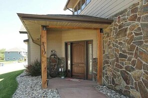 A house with a stone exterior, a wooden front door, and a number '308' on the post. - Big 4BR Near Mt Rushmore • Fireplace • Rapid City (Rapid City)