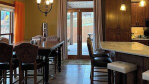 Una cocina con comedor, muebles de madera y una isla grande.