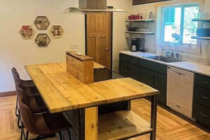 A kitchen with a wooden table, chairs, a stove, and cabinets. - Honey Bee Hideaway- Dog-Friendly Home - Porch & Mtn Views (Lead)
