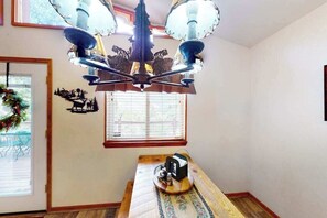 A room with a chandelier, a window with blinds, a wooden bench, and a wall-mounted decoration. - Horseshoe Haven - Mountain-View Home • Deck & Grill (Divide)