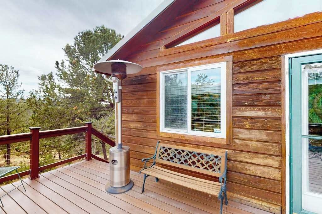 A wooden deck with a bench and a patio heater.