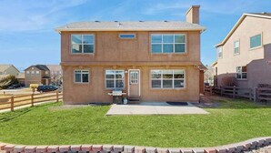 A two-story house with a front porch, a garage, and a well-maintained lawn. - Jack’s Ranch House- Family Home • Game Room & Mtn Views (Colorado Springs)