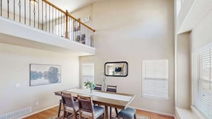 A dining area with a wooden table, chairs, and a patterned rug. - Jack’s Ranch House- Family Home • Game Room & Mtn Views (Colorado Springs)