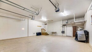 Ein geräumiger, leerer Raum mit hoher Decke, einer Treppe und einem kleinen Tisch.