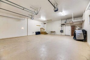 Ein geräumiger, leerer Raum mit hoher Decke, einer Treppe und einem kleinen Tisch.
