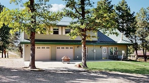 A two-story building with a garage, a covered patio, and a swing set. - Legacy Lodge - 4BR Lodge Minutes from Deadwood (Sturgis)