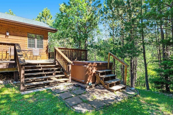 A wooden cabin with a deck, outdoor seating, and a hot tub. - Lazy Bear Lodge - Rustic Lodge • Hot Tub & Wrap Deck (Sturgis)