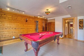 A pool table with a red felt surface, wooden walls, and a ceiling light fixture. - Mills Ranch - Hot Tub Cabin • Pikes Peak Views (Woodland Park)