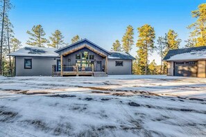 A two-story house with a front porch, a garage, and a driveway. - Pillar Peak Perch - Luxury Lodge • Hot Tub & Big Views (Sturgis)