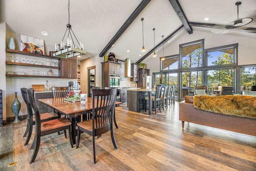 A spacious kitchen with a dining area, large windows, and a cozy seating area.