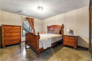 Une chambre à coucher avec un lit en bois, une commode et une table de chevet.