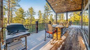 Eine Terrassenausstattung mit Grill, Stühlen und Tisch.