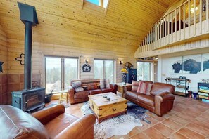 Ein gemütliches Wohnzimmer mit Ledersofas, einem Holztisch und einem Kamin.