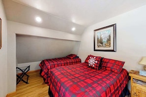 A bedroom with two beds, a wooden floor, a ceiling light, and a framed picture on the wall. - Buffalo Lodge - Ski-Area Cabin • Hot Tub & Views (Lead)