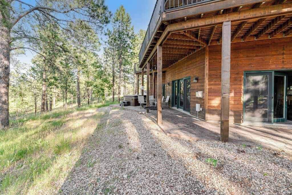 A wooden cabin with a covered porch and a gravel driveway.