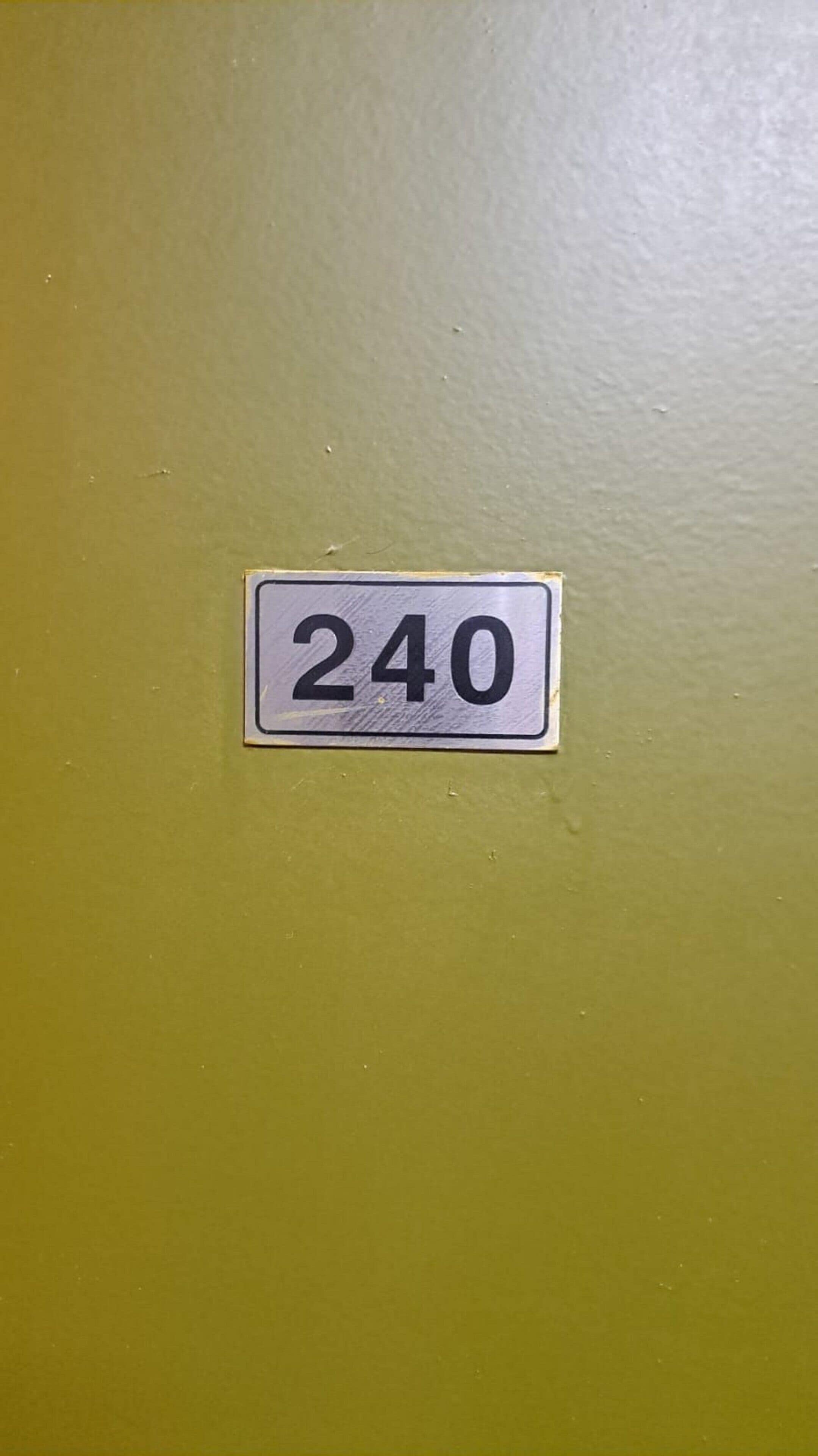 A wall with a number sign '240' on it.