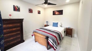 A bedroom with a bed, a dresser, a nightstand, and a ceiling fan. - Spacious Townhome near Disney (Davenport)