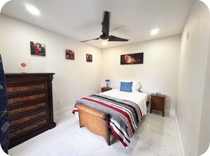 A bedroom with a bed, a dresser, a nightstand, and a ceiling fan. - Spacious Townhome near Disney (Davenport)