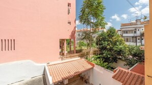 Un edificio residencial con fachada roja, tejado de tejas y un balcón.