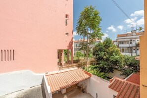 Ein Wohngebäude mit roter Fassade, einem Ziegeldach und einem Balkon.