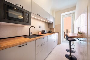 A modern kitchen with a built-in microwave, a sink, and a coffee maker. - GuestReady - Stay in the Heart of Lisbon (Lisbon)