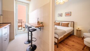 Un dormitorio pequeño con cama, mesita de noche y una lámpara pequeña de noche.