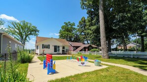 A residential neighborhood with houses, a sidewalk, and a playground. - Paddle & Play on Long Lake - Lakefront Retreat (Scotts)