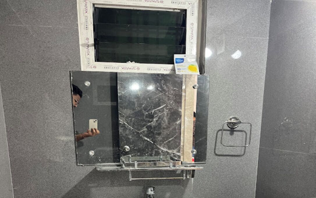 A bathroom with a mirror, a towel rack, and a window.