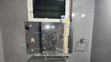 A bathroom with a mirror, a towel rack, and a window.