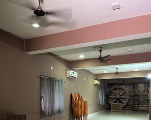 Una stanza con ventilatori a soffitto, una grande ruota decorativa e un’area salotto con poltrone.