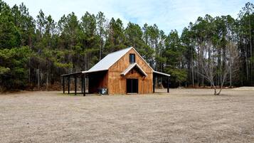 A wooden barn with a gabled roof and a covered entrance.