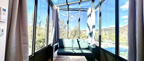 Ein Zimmer mit Glasdecke, einer Couch und einem Holztisch.