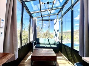A room with a glass ceiling, a sofa, and a wooden table. - Fantastic Tiny House Fully Equipped with Glass Ceiling in Orderville, Utah (Orderville)
