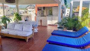 A covered outdoor area with a sofa, lounge chairs, and potted plants. - Close to the ocean—the perfect spot to explore Puerto Plata on foot (Puerto Plata)