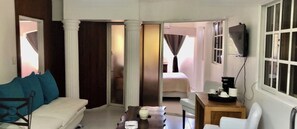 A hotel room with a sofa, a small table, a TV, and a bed. - Close to the ocean—the perfect spot to explore Puerto Plata on foot (Puerto Plata)