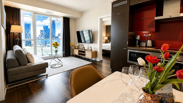 A modern hotel room with a sofa, dining table, and kitchen area. - Chic RogersCenter MTCC 2B2B Lake&CN Tower  Free Parking (Toronto)