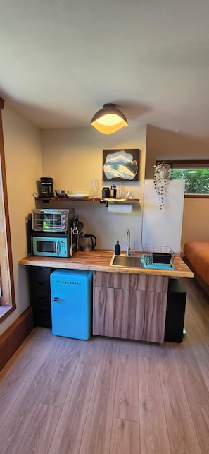 A compact kitchen with a built-in dishwasher, a coffee maker, and a toaster.