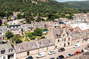 Un quartier résidentiel avec des maisons, une rue et un paysage vallonné en arrière-plan.